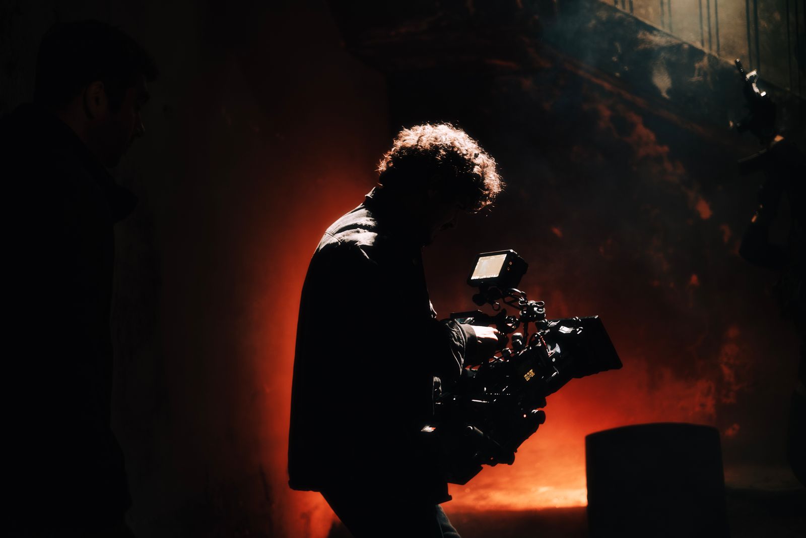 Silhouette of a cinematographer against warm set lighting