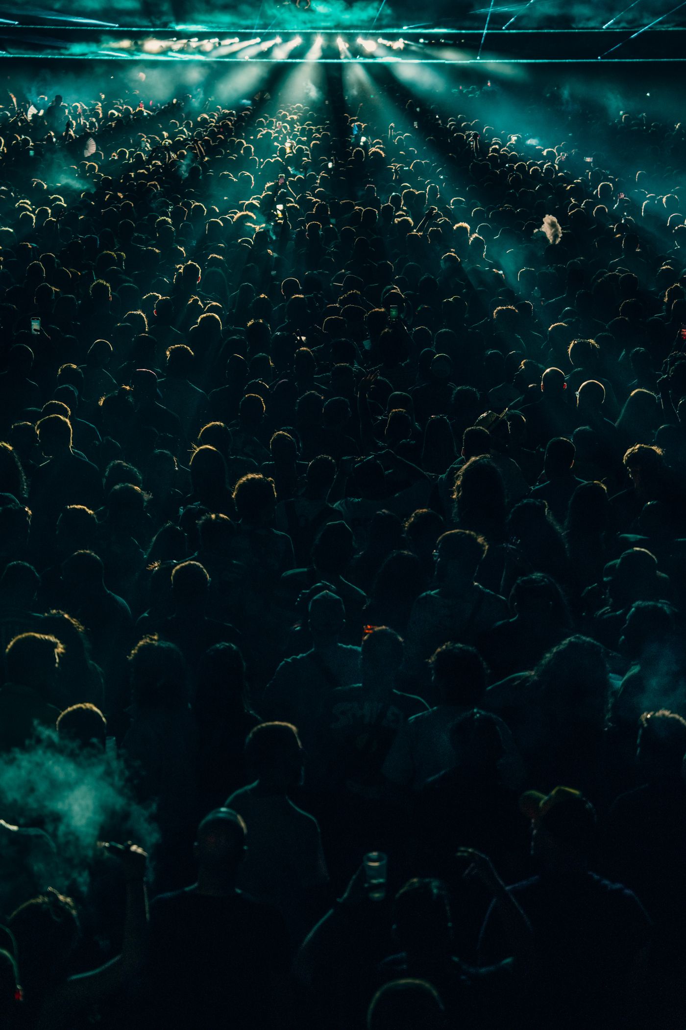 A concert crowd under dramatic stage lighting